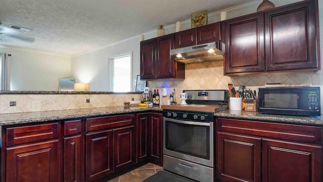 kitchen with a textured ceiling, dark tile patterned floors, dark stone counters, tasteful backsplash, and stainless steel range with gas cooktop