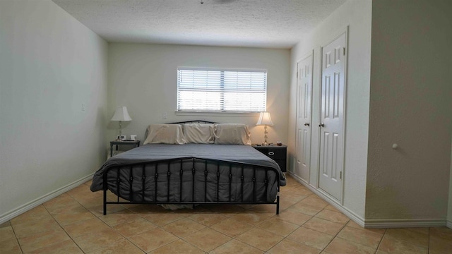 bedroom featuring light tile patterned floors and a textured ceiling