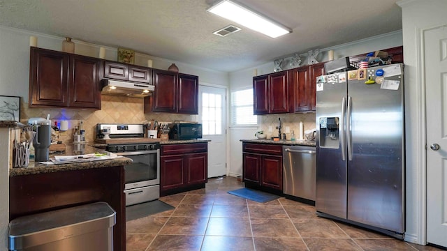 kitchen with backsplash, crown molding, stainless steel appliances, and a textured ceiling