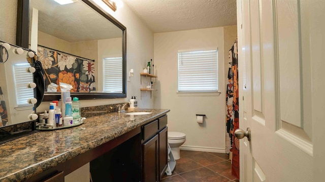 bathroom featuring a textured ceiling, tile patterned floors, vanity, and toilet