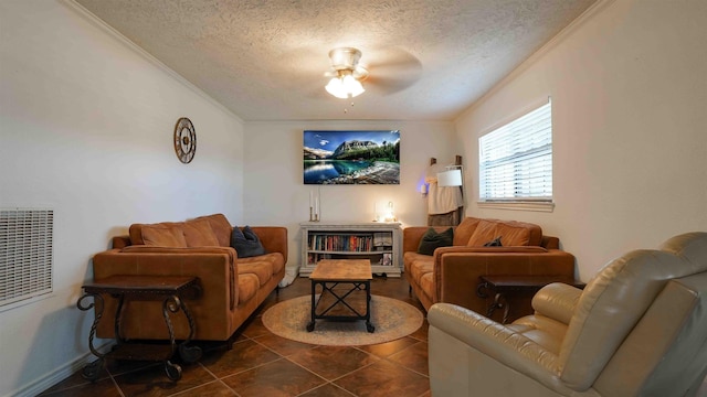 living room with a textured ceiling, ceiling fan, crown molding, and dark tile patterned floors