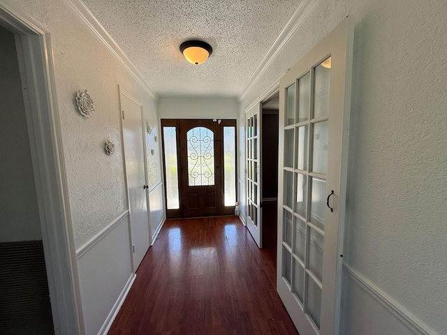 entryway with french doors, dark wood-type flooring, a textured ceiling, and ornamental molding