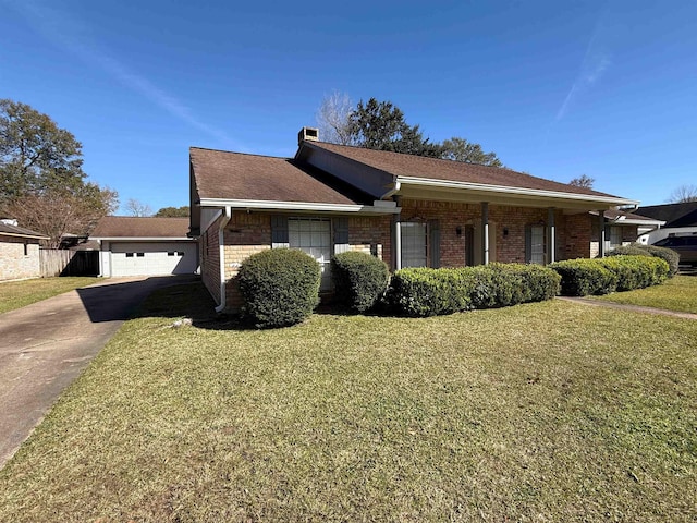 view of front of property with a garage, an outbuilding, and a front lawn