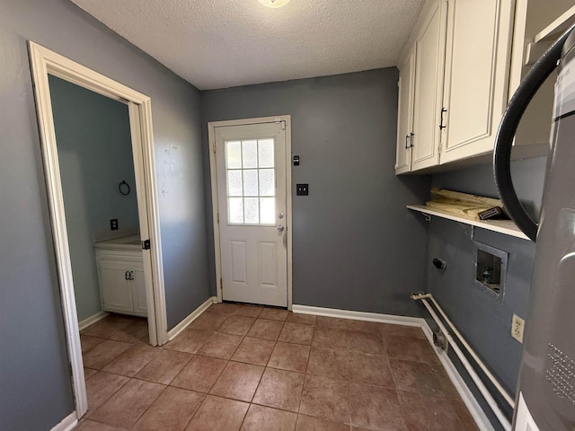 washroom featuring cabinets, washer hookup, a textured ceiling, and tile patterned floors