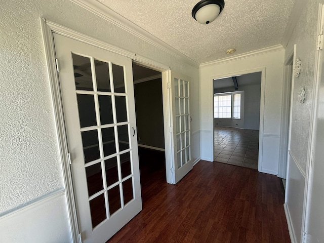 corridor with french doors, dark hardwood / wood-style flooring, a textured ceiling, and crown molding