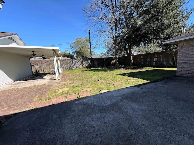 view of yard featuring ceiling fan and a patio area