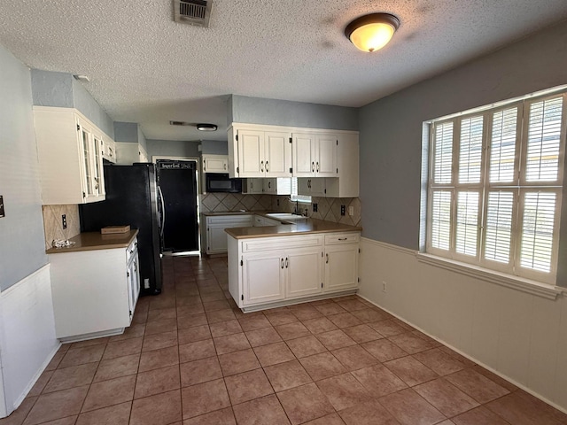 kitchen with decorative backsplash, sink, white cabinets, and tile patterned flooring