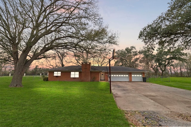 single story home featuring a yard, a garage, driveway, and a chimney