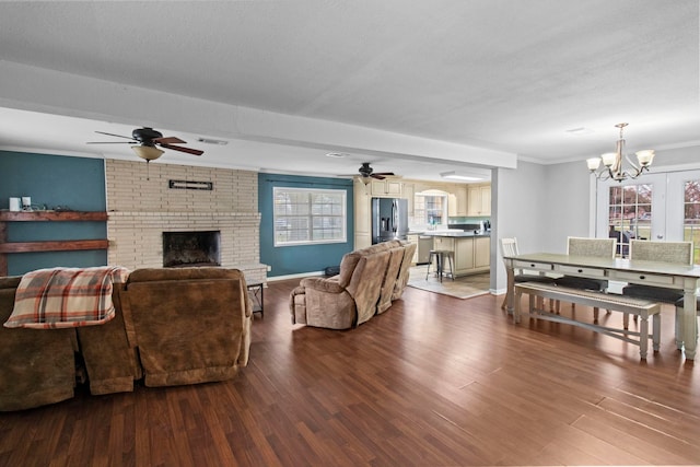 living area featuring a brick fireplace, a healthy amount of sunlight, visible vents, and ornamental molding