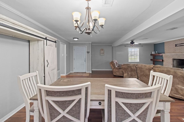 dining area featuring visible vents, ornamental molding, dark wood-style floors, a barn door, and baseboards