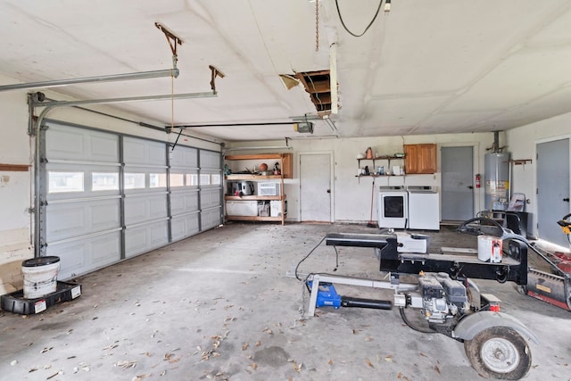 garage featuring gas water heater, a garage door opener, and washer and dryer