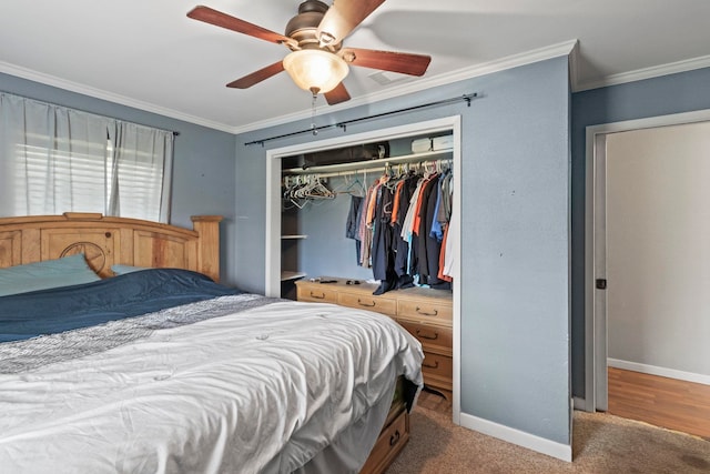 bedroom with carpet, baseboards, ceiling fan, a closet, and crown molding