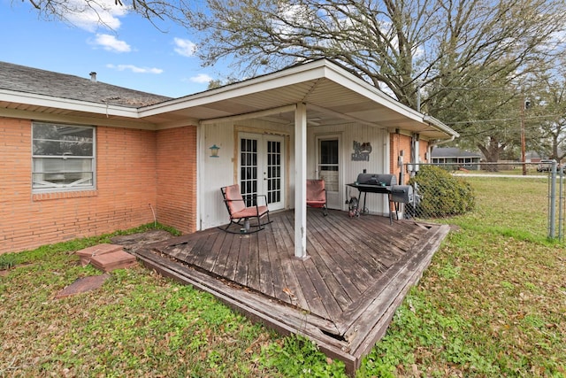 wooden deck featuring a yard, french doors, fence, and a grill