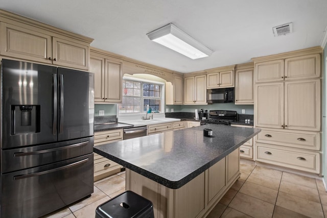 kitchen with dark countertops, light tile patterned flooring, visible vents, and stainless steel appliances