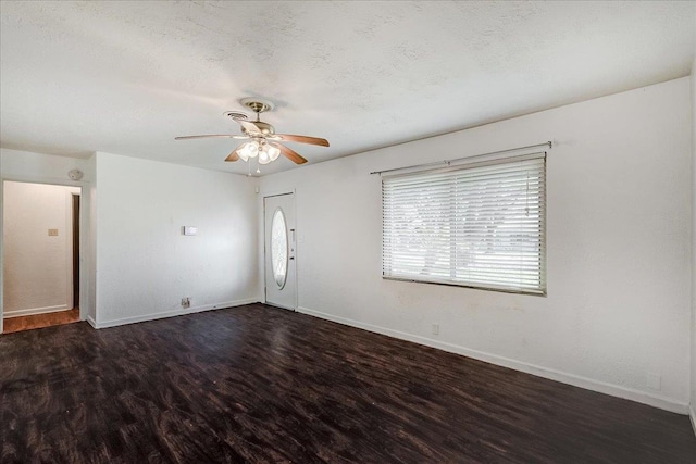 empty room with ceiling fan, a textured ceiling, and dark hardwood / wood-style flooring