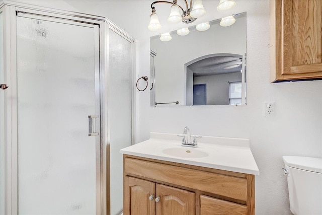 bathroom featuring vanity, toilet, and a shower with shower door