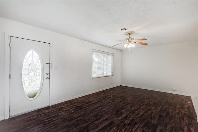 entrance foyer featuring ceiling fan, a textured ceiling, and dark hardwood / wood-style flooring