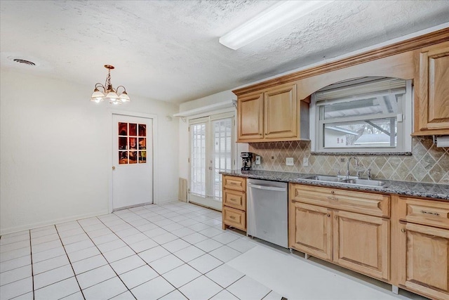 kitchen with backsplash, stainless steel dishwasher, sink, and dark stone countertops