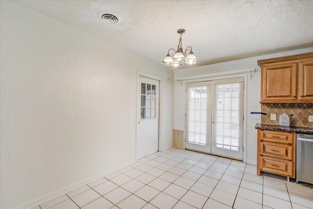 interior space with a textured ceiling, a chandelier, and light tile patterned flooring