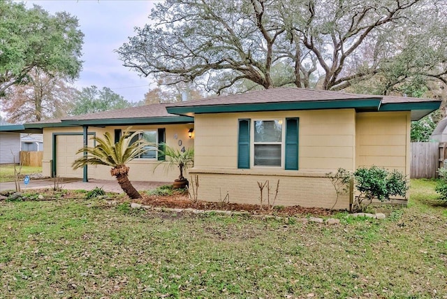 single story home with a garage and a front lawn