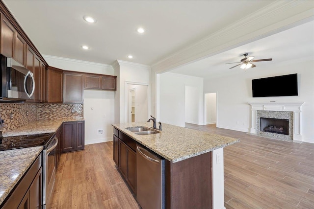 4406 Sequoia, Orange, TX 77630 - kitchen featuring stainless steel appliances, a sink, a ceiling fan, light stone countertops, and a kitchen island with sink