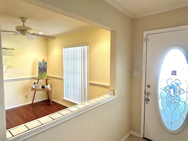 foyer entrance with ceiling fan and ornamental molding