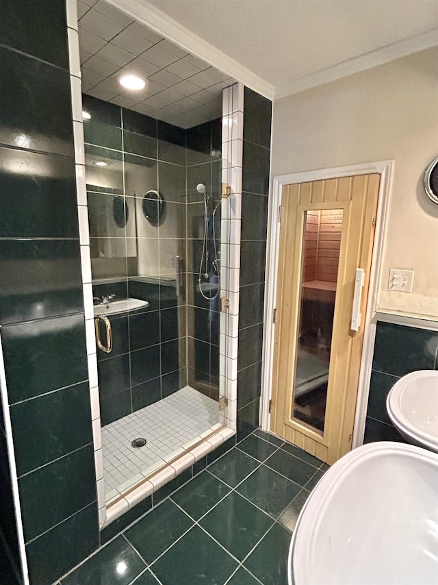 bathroom with tile patterned floors, a shower with door, and crown molding