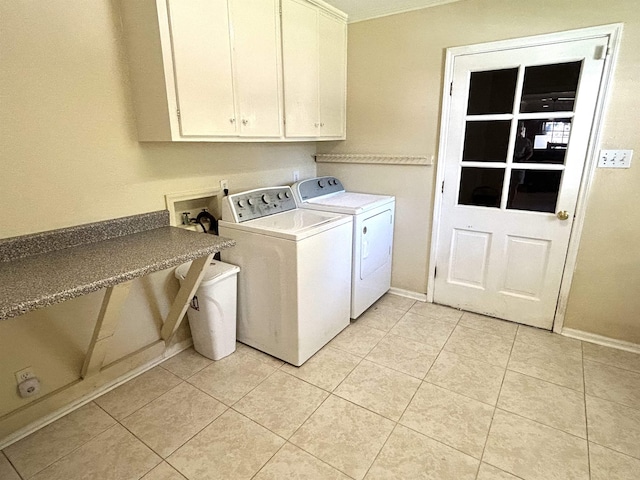 clothes washing area with cabinets, independent washer and dryer, and light tile patterned floors