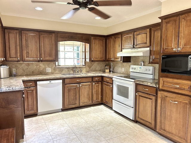 kitchen featuring light tile patterned floors, white appliances, light stone counters, and sink