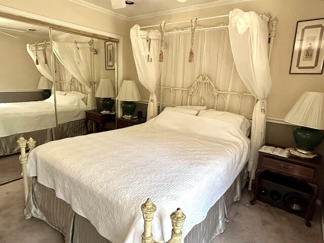 carpeted bedroom with crown molding and a closet