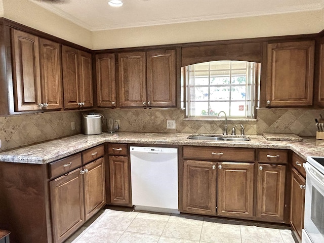 kitchen featuring light stone countertops, white appliances, sink, and tasteful backsplash