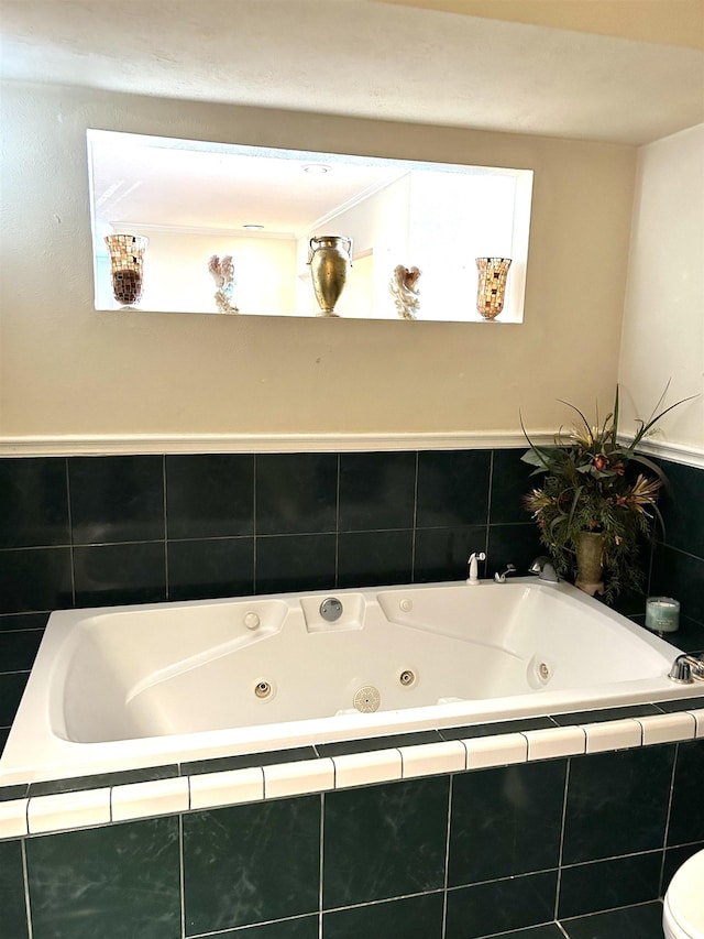 bathroom with tile patterned flooring, tiled bath, and toilet