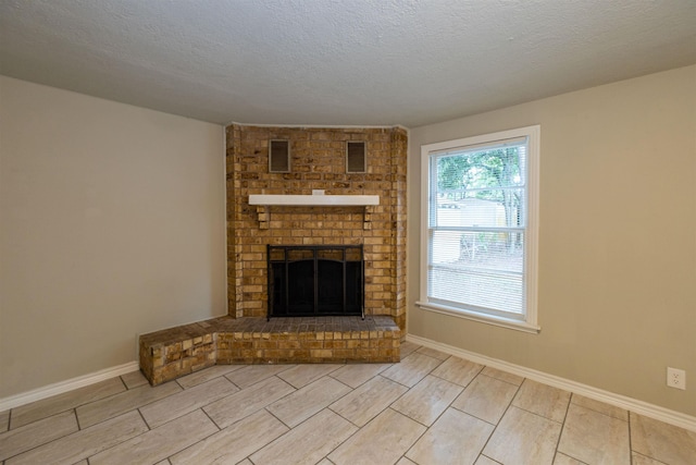 unfurnished living room featuring a fireplace and a textured ceiling