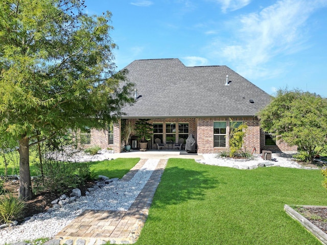 rear view of property with a yard and a patio