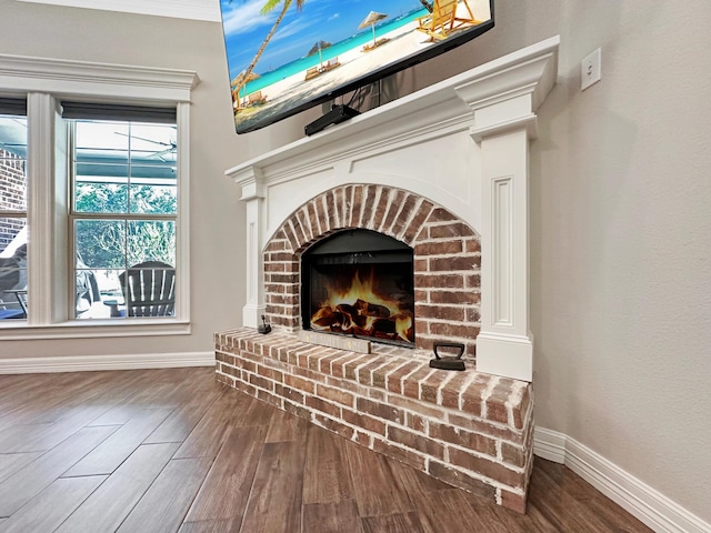 interior details with hardwood / wood-style floors and a brick fireplace