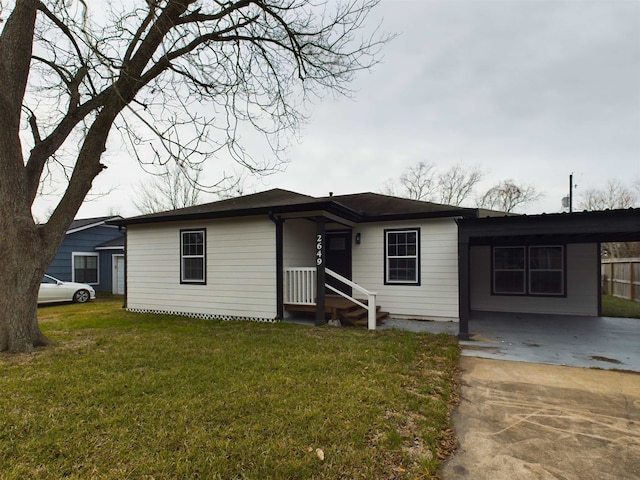 ranch-style house featuring a carport and a front lawn