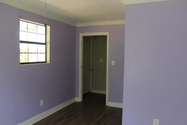 spare room featuring dark hardwood / wood-style flooring and ornamental molding