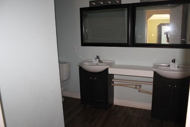 bathroom with toilet, vanity, and hardwood / wood-style flooring