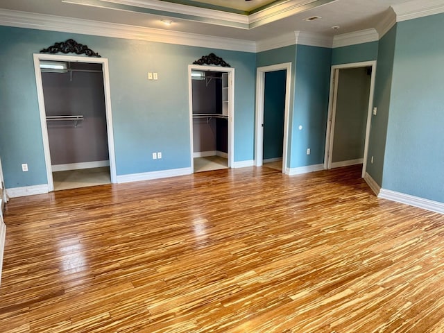6748 Jefferson Blvd, Groves, TX 77619 - unfurnished bedroom with wood finished floors, multiple closets, and ornamental molding