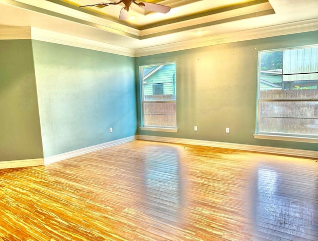 6748 Jefferson Blvd, Groves, TX 77619 - spare room with a raised ceiling, crown molding, healthy amount of natural light, a ceiling fan, and wood finished floors