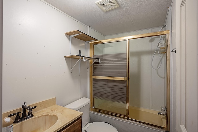 full bathroom with vanity, bath / shower combo with glass door, a textured ceiling, and toilet