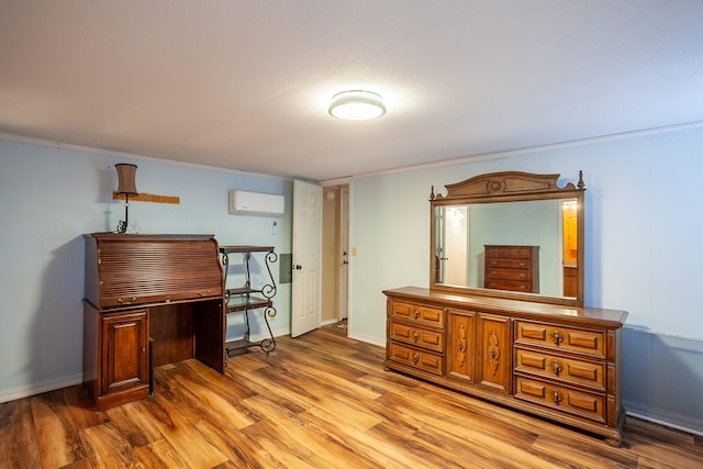 miscellaneous room with light hardwood / wood-style flooring and a wall unit AC