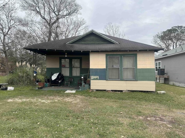 rear view of house with a lawn and cooling unit