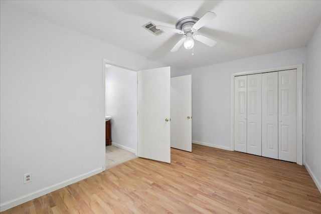 1336 Beagle Rd, Orange, TX 77632 - unfurnished bedroom with light wood-style flooring, a closet, connected bathroom, and a ceiling fan