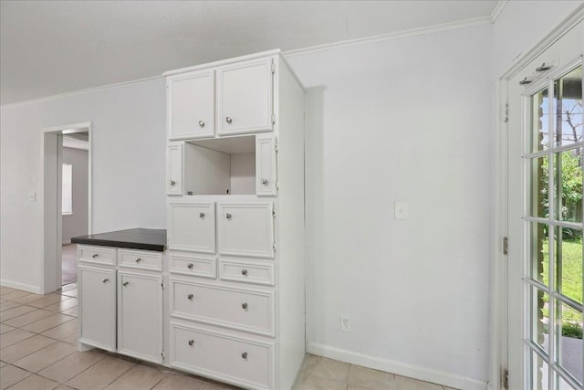 1336 Beagle Rd, Orange, TX 77632 - kitchen featuring plenty of natural light, light tile patterned floors, white cabinetry, crown molding, and dark countertops