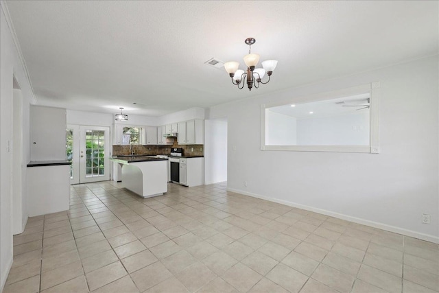 1336 Beagle Rd, Orange, TX 77632 - kitchen with a chandelier, white cabinets, open floor plan, tasteful backsplash, and a kitchen island
