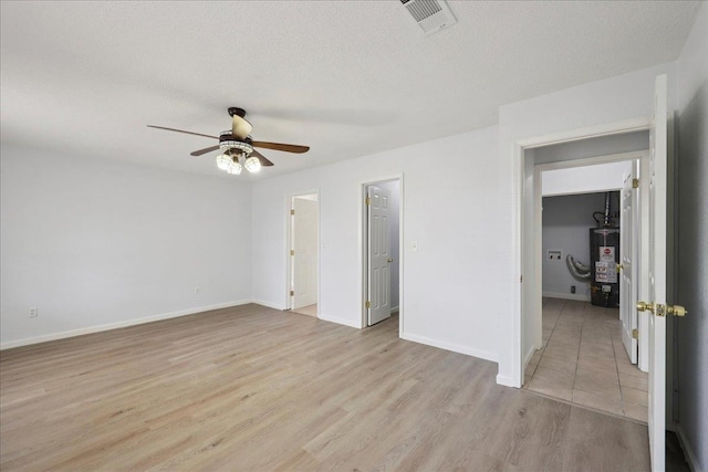 1336 Beagle Rd, Orange, TX 77632 - empty room featuring gas water heater, a ceiling fan, light wood-type flooring, and a textured ceiling