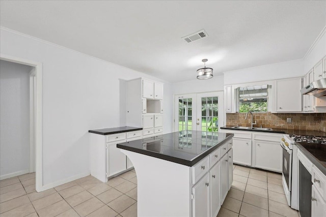 1336 Beagle Rd, Orange, TX 77632 - kitchen with white range with gas stovetop, dark countertops, white cabinetry, and ornamental molding