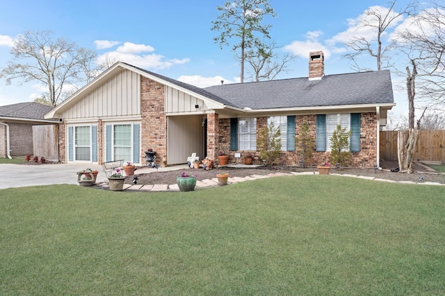 mid-century home featuring brick siding, fence, a chimney, and a front lawn