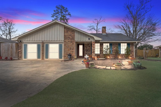 view of front facade featuring driveway, brick siding, a chimney, and an attached garage